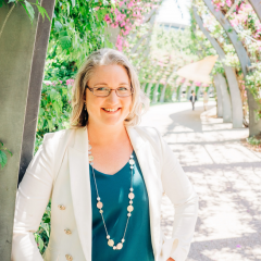 Picture of Glenys Oberg under a bougainvillea arch